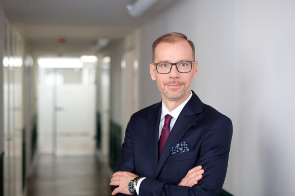 Na zdjęciu widoczny Maciej Barszczewski, Członek Zarządu, CERES Dom Inwestycyjny. W tle korytarz w biurze.
